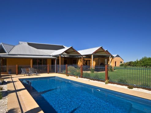 Compass X Trainer fibreglass pool with tiling around the pool