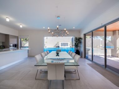 Compass fibreglass pool with a glass wall and a pool water feature